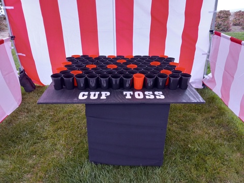 Cup toss carnival game with black and orange cups