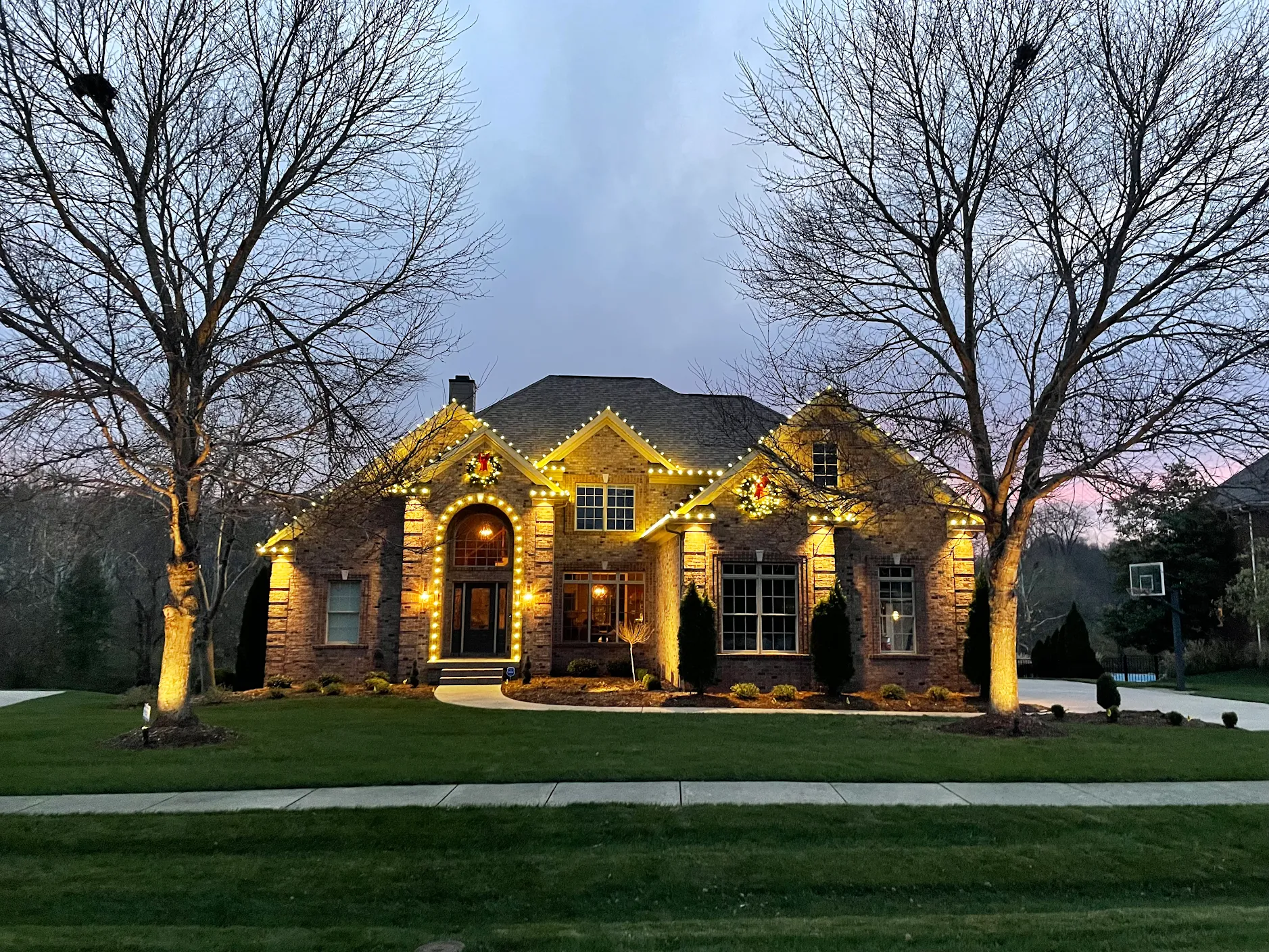 Warm-white C9 LED Christmas light installation on a home at dusk — Lower Mainland BC